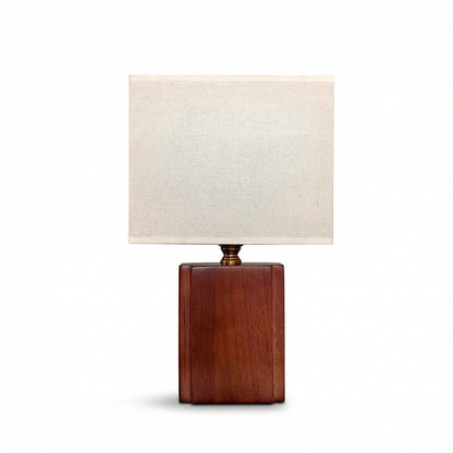 Table lamp with wooden base and white shade on a white background