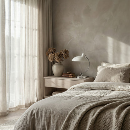 Neatly made bed with beige bedding in a bedroom setting.