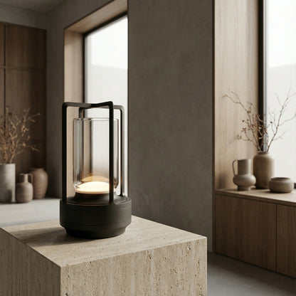 Modern black lantern with candle on a stone surface in a minimalistic room.