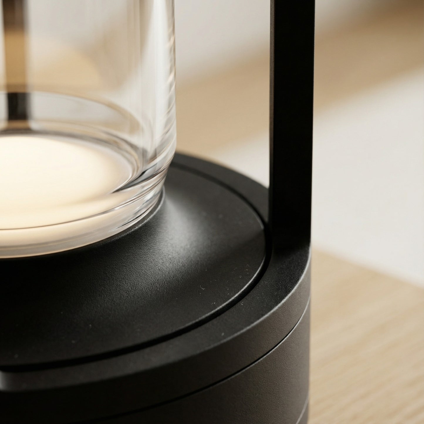 Close-up of a modern black lamp with a glass shade on a wooden surface.