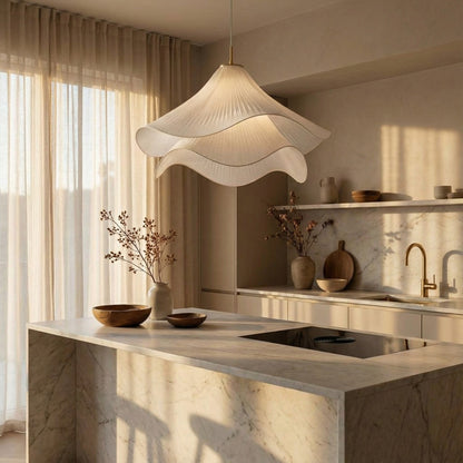 Modern kitchen with marble island, pendant light, and decorative elements.