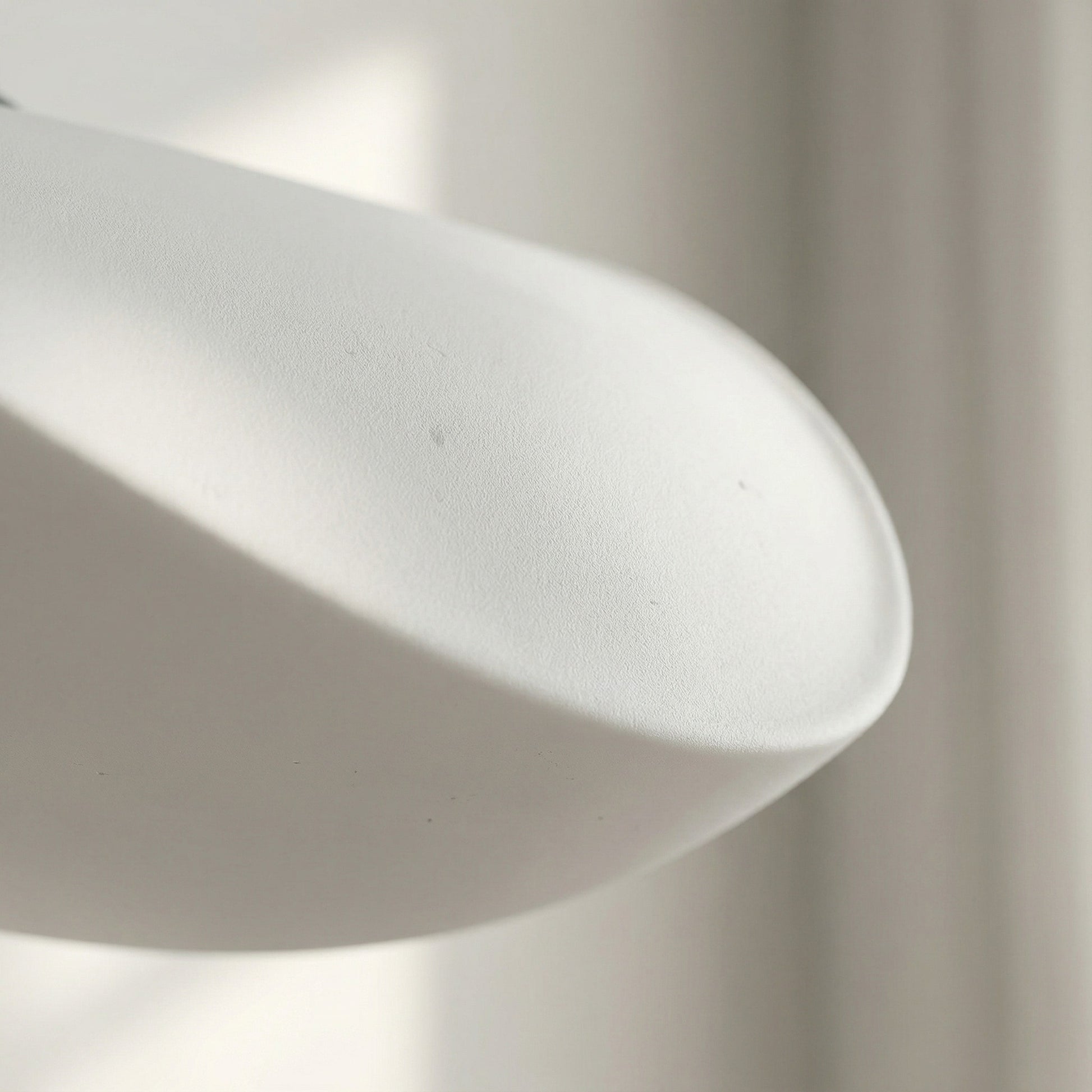 Close-up of a white pendant light with a blurred background