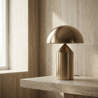 Gold table lamp on a stone surface with a neutral wall background