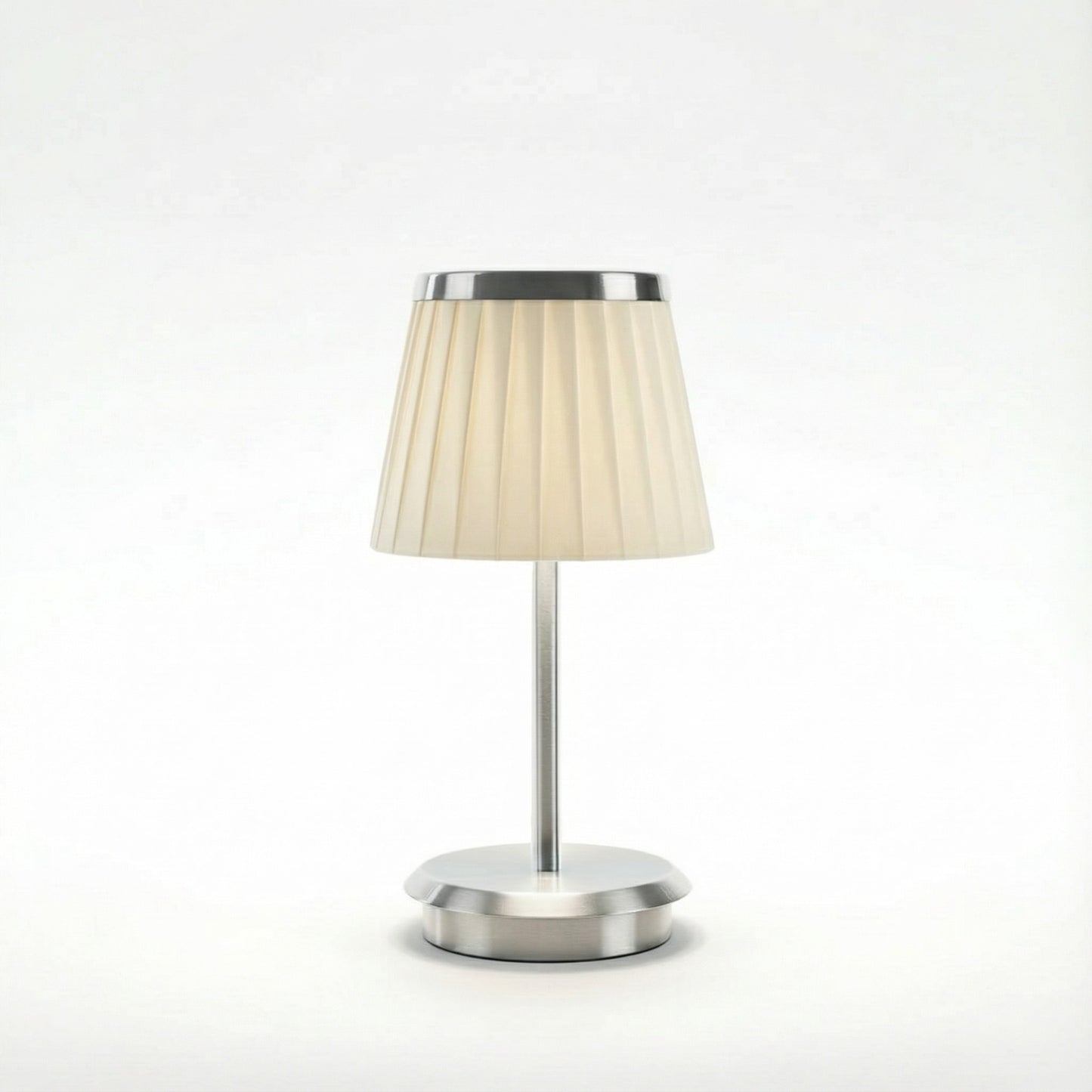 Table lamp with a beige shade and silver base on a white background
