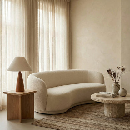 Modern living room with a beige sofa, wooden side table, and stone coffee table.