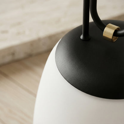 Close-up of a modern lamp with black base and white shade on a wooden surface.