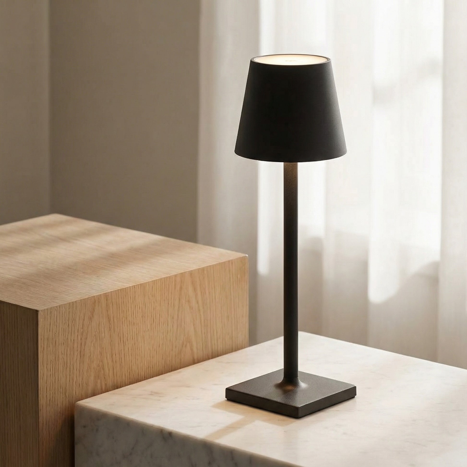 Black table lamp on a marble surface with a neutral background