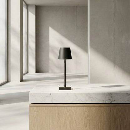 Black table lamp on a marble surface with geometric wall design