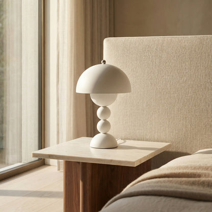 Modern table lamp on a side table next to a sofa with neutral tones.