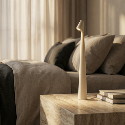 Decorative lamp on a wooden table with a sofa and curtains in the background