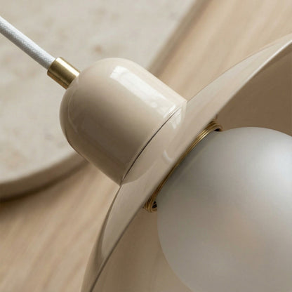 Close-up of a beige ceiling light fixture on a wooden surface