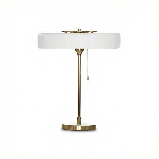 Table lamp with white shade and brass base on a white background