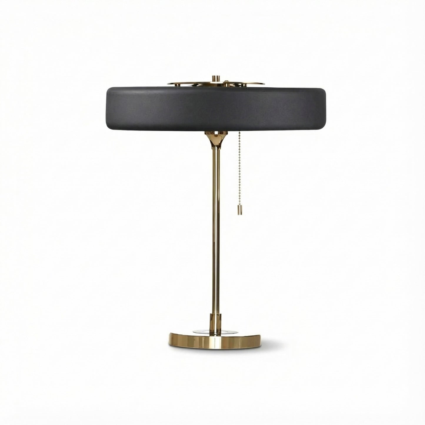 Table lamp with black shade and brass base on a white background