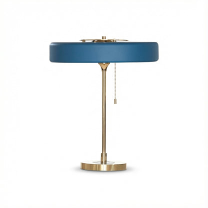 Table lamp with blue shade and brass base on a white background