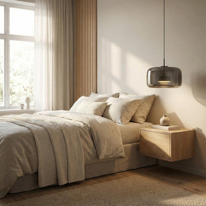 Modern bedroom with beige bedding, wooden nightstand, and pendant light.