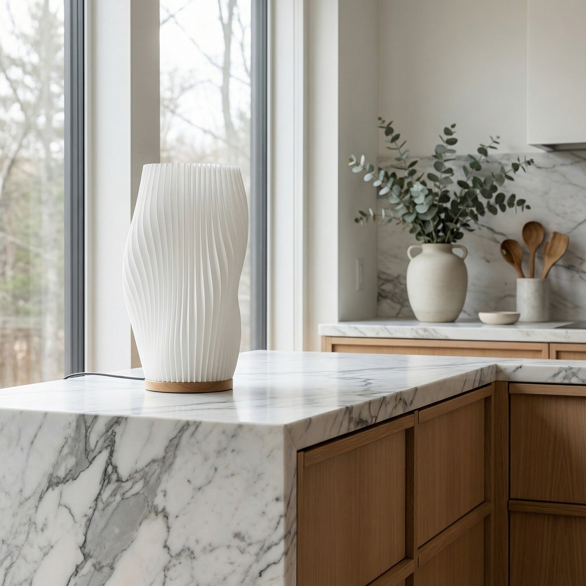 Modern kitchen with marble countertop, wooden cabinets, and decorative items.