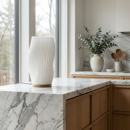 Modern kitchen with marble countertop, wooden cabinets, and decorative items.