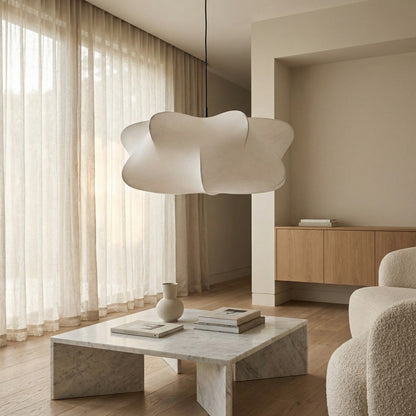Modern living room with a marble coffee table, white vase, and abstract pendant light.